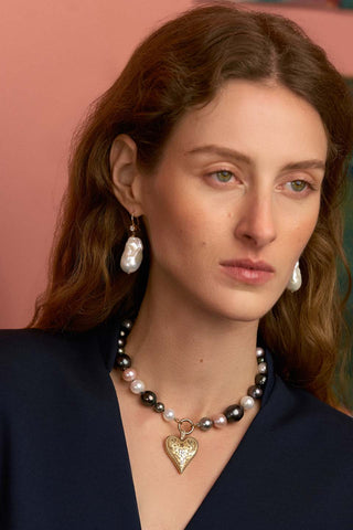 Close-up of model wearing a pearl necklace and earrings