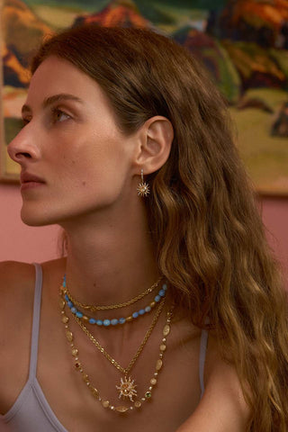 Model wearing sun earrings and necklace staack