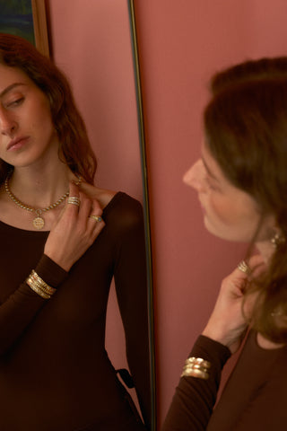 Model wearing necklace and rings