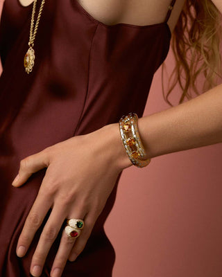 Close-up of Model wearing a bracelet and rings with gemstones 