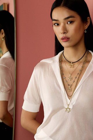 Model wearing multiple necklaces 