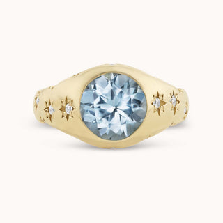 Gold ring with an aquamarine and smaller diamonds set in star bezels