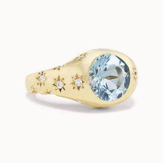Gold ring with an aquamarine and smaller diamonds set in star bezels
